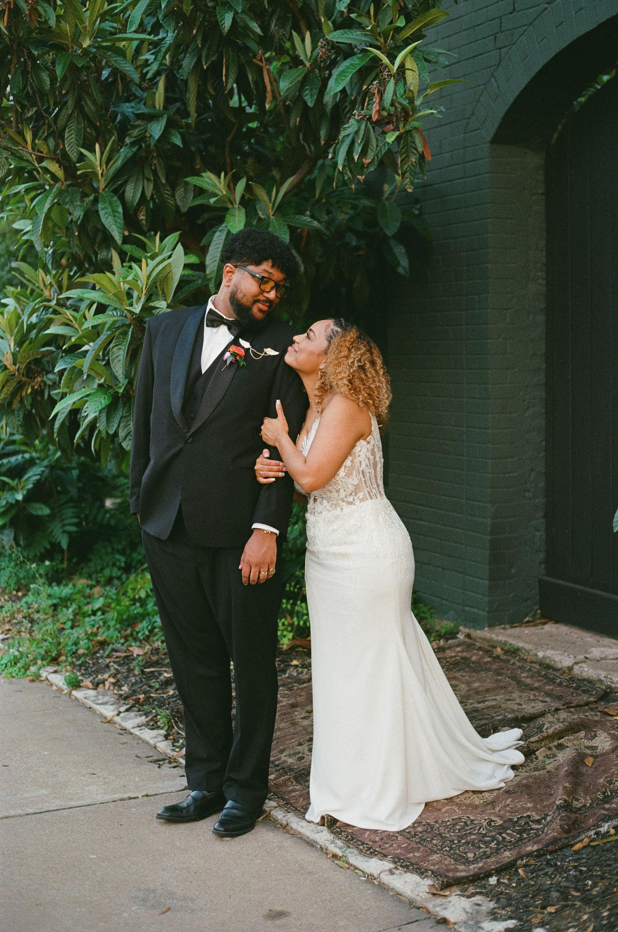 Groom and bride wedding portrait in front of garden wall