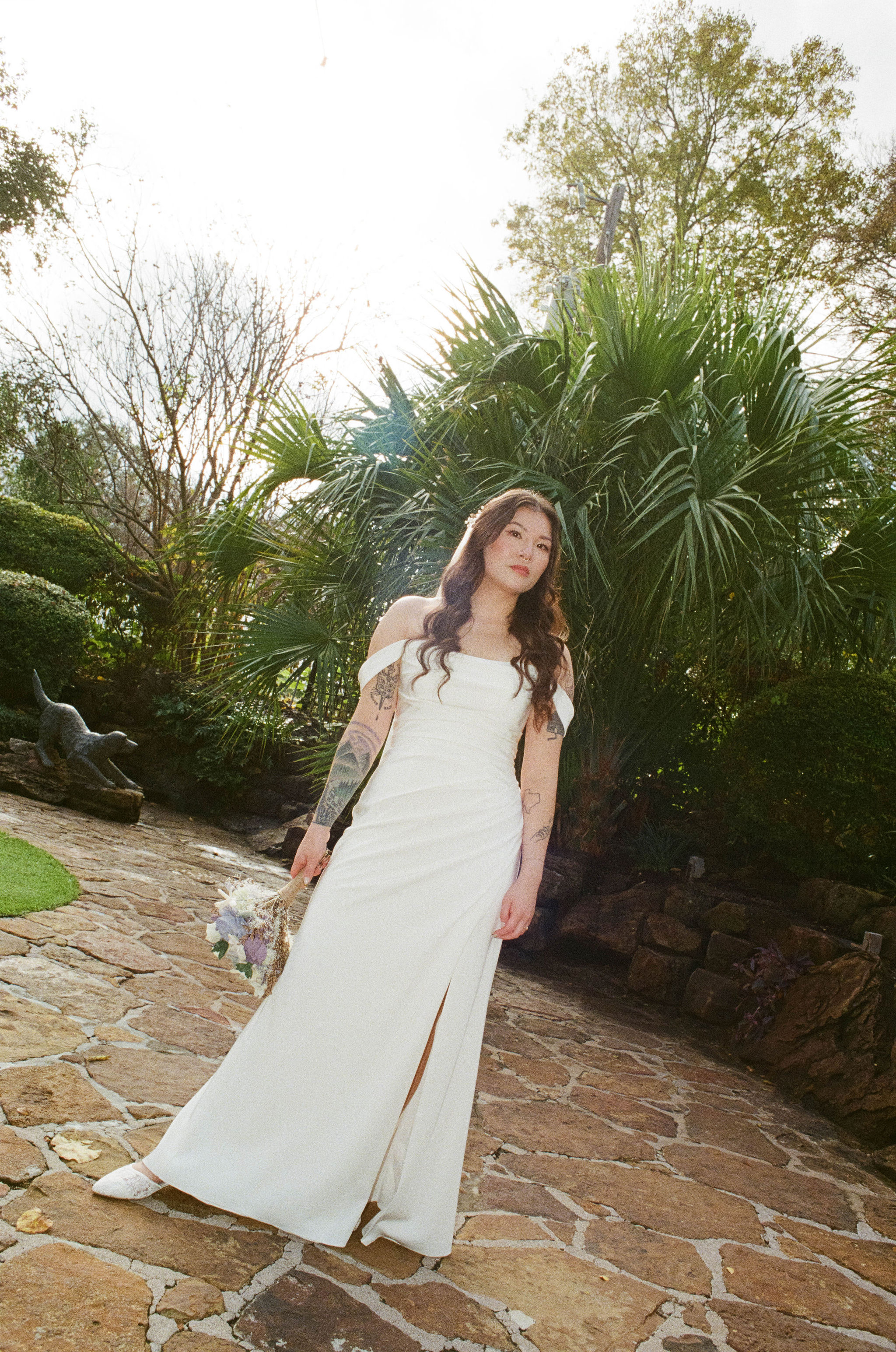 Bride standing in front of palm tree at hummingbird house in austin, texas