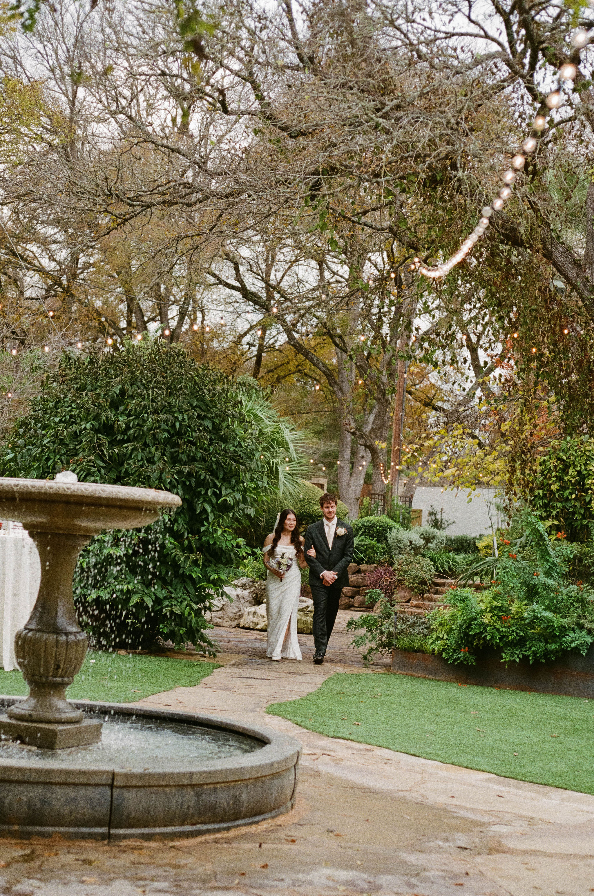 Bride and groom walking through garden at Hummingbird House in Austin, Texas