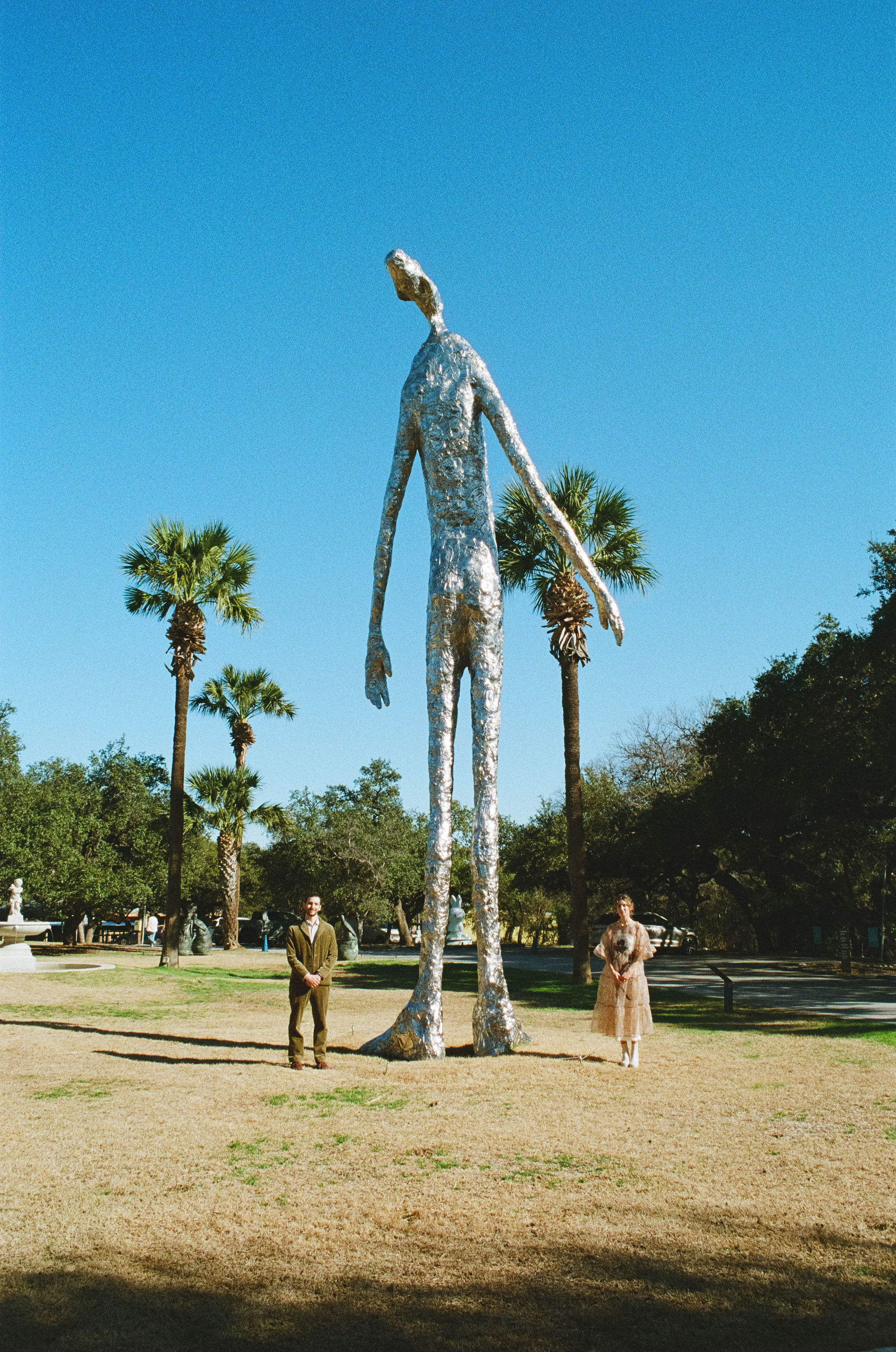 Couple posing with statue outside of Laguna Gloria in Austin, Texas