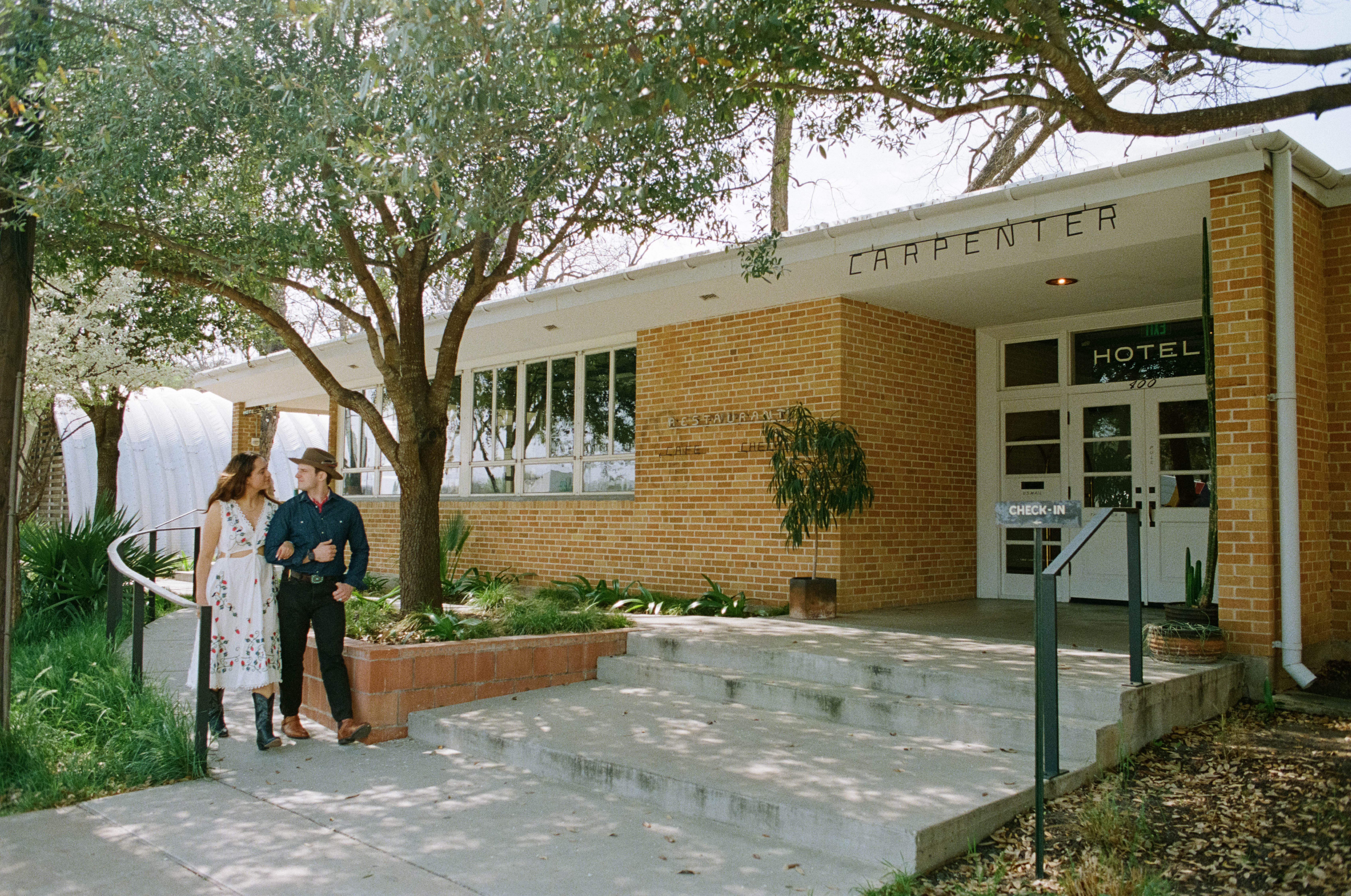 Couple walking together in front of Carpenter Hotel in Austin, Texas