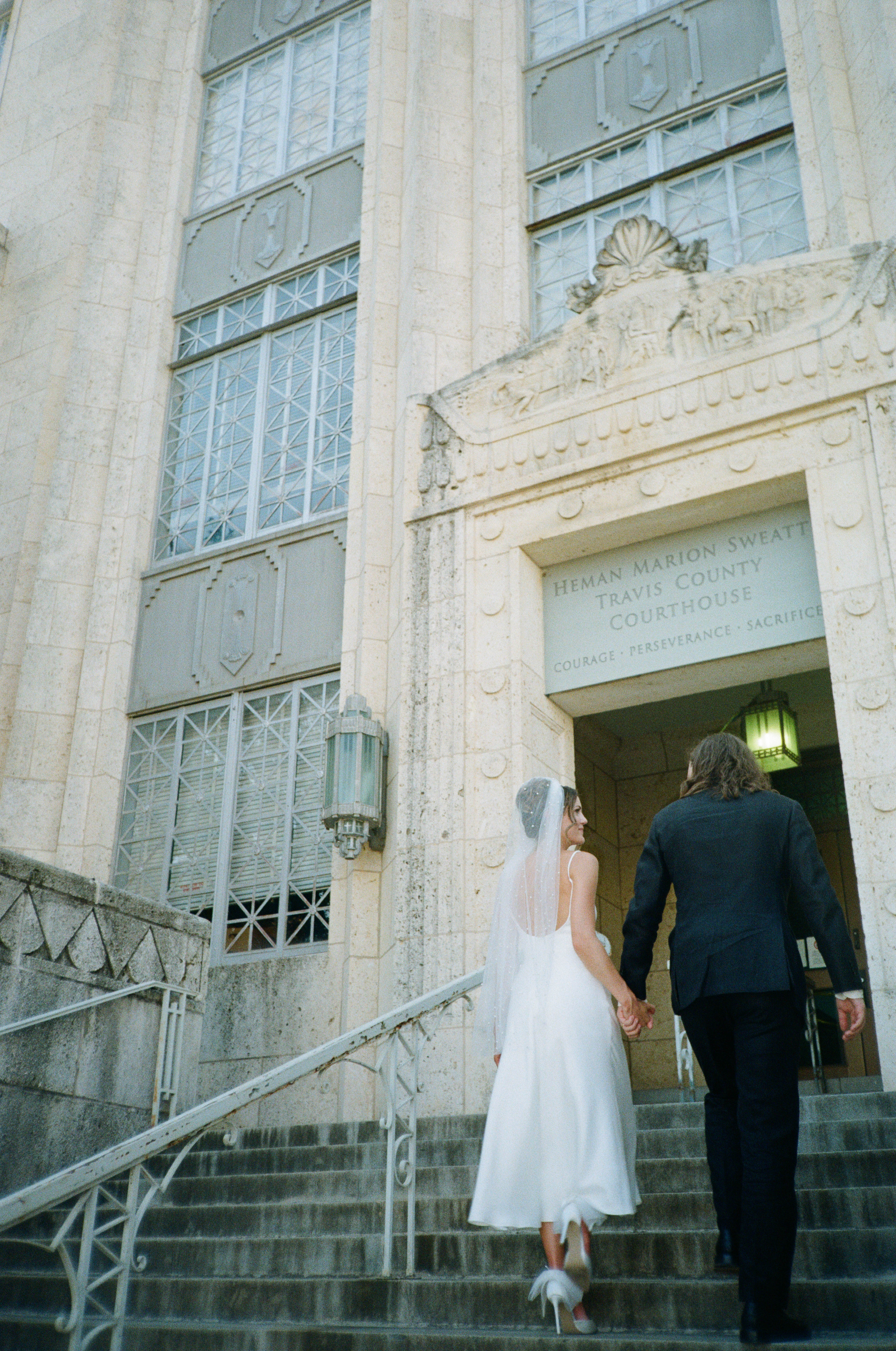 Bride and groom walking up stairs at Travis County Court House